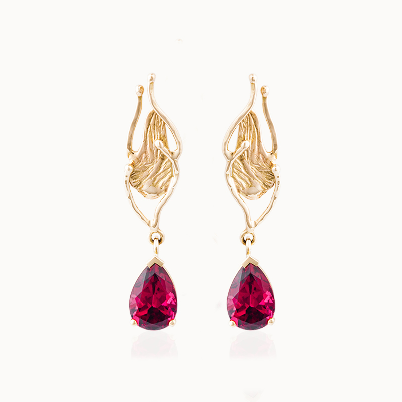 Crafted from 18-karat gold, these earrings are set with pear-cut garnet gemstones.