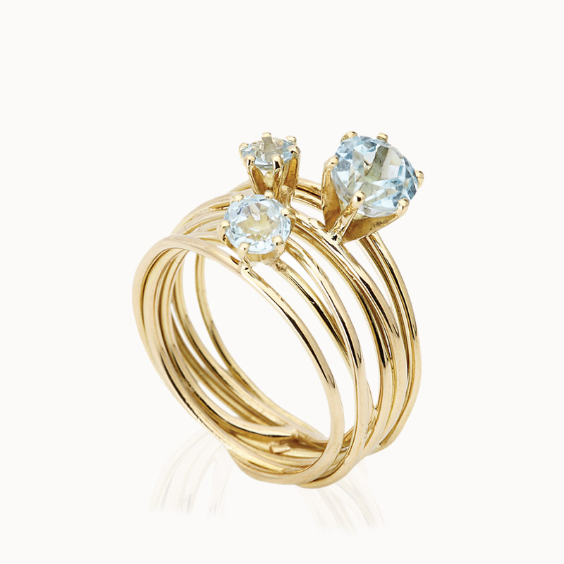 18K gold ring set with 3 round topaz gemstones in different dimensions.