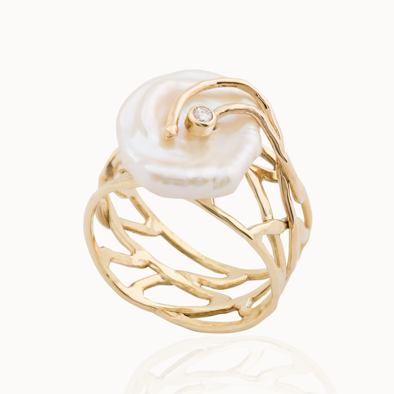 Crafted from 18-karat yellow gold, the ring is set with a baroque pearl and a 0,06 ct brilliant cut diamond.