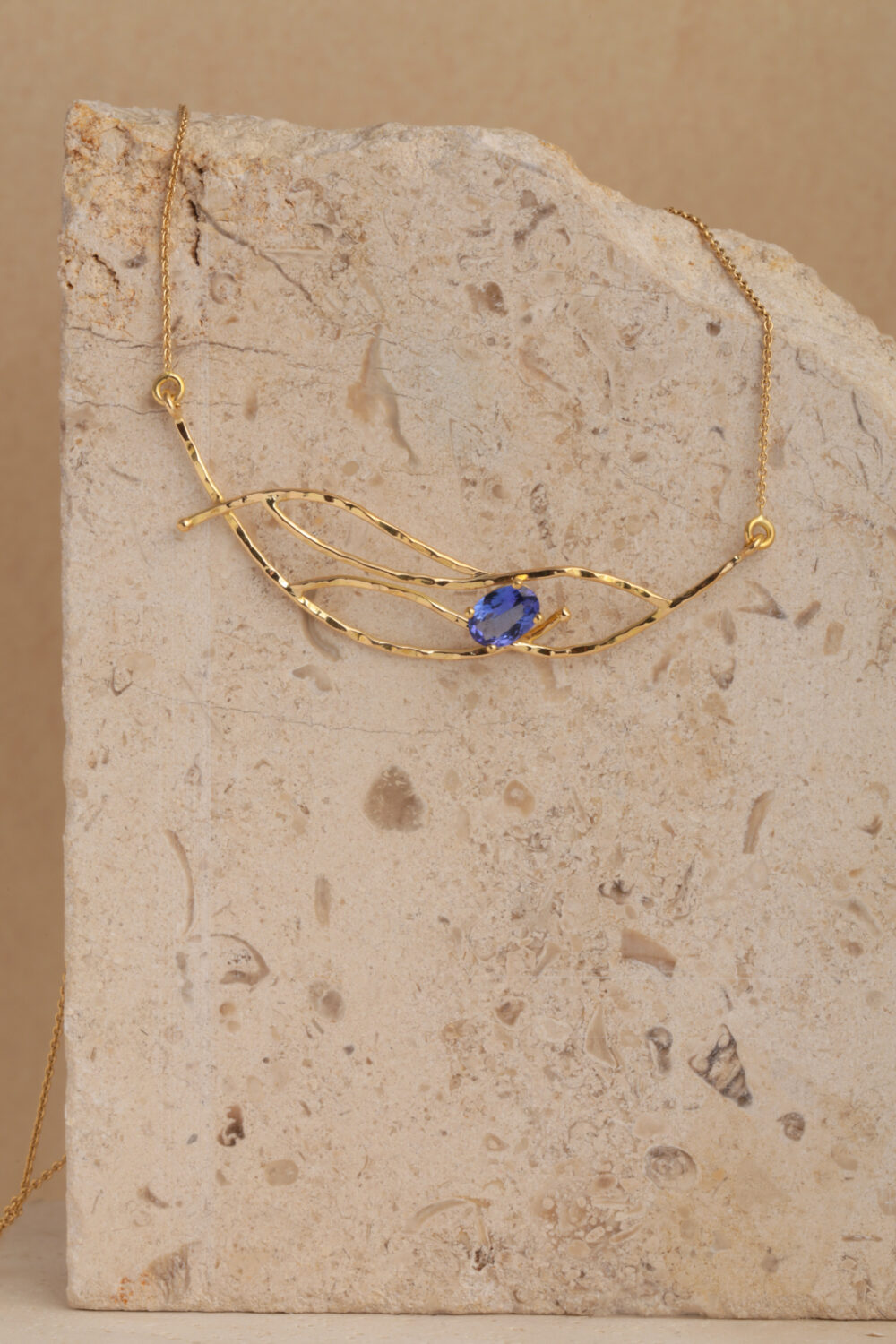 Crafted from 18-karat gold, this necklace is set with an oval-cut tanzanite gemstone.