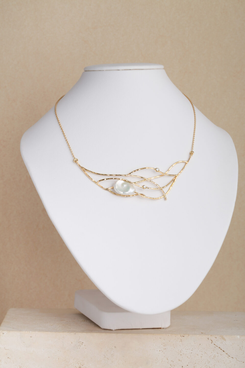 Halsketting gemaakt van 18-karaats goud met twee briljantgeslepen diamanten en een barokparel.