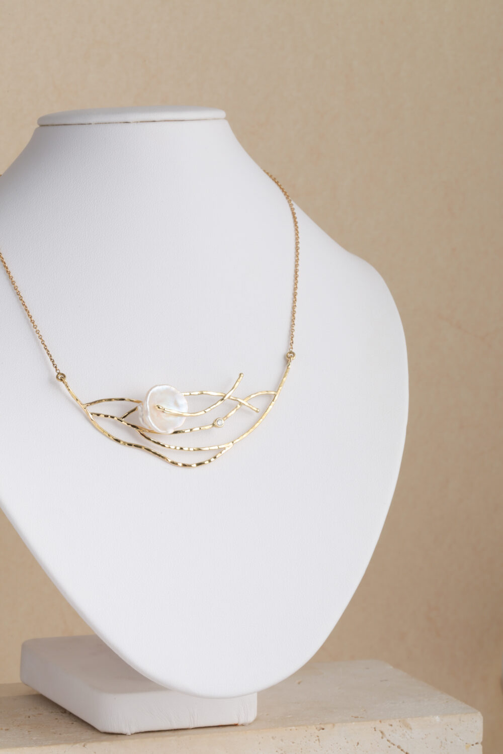 Halsketting vervaardigd uit 18-karaats goud bezet met een briljant geslepen diamant en een barokke, natuurlijke parel. Al onze sieraden worden met de hand gemaakt in ons atelier in Antwerpen.
